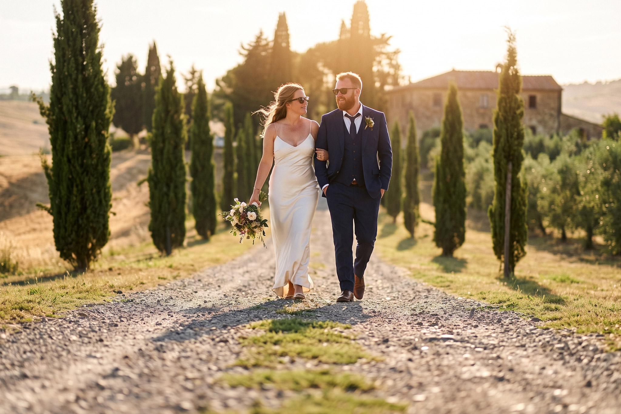 Couple walking a cypress-lined track at golden hour, Tuscany