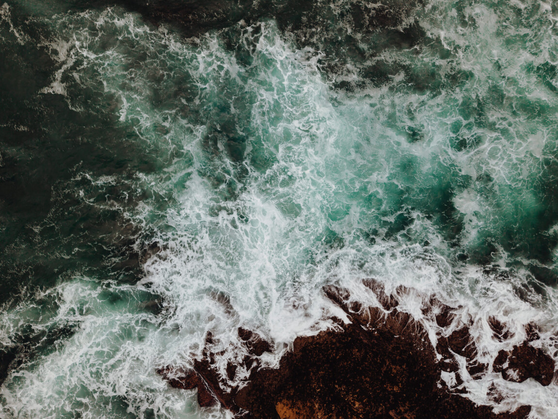 Tunnels Beaches wedding photographer Matt Wing: drone photograph of waves breaking over rocks, taken on the Cornish coast