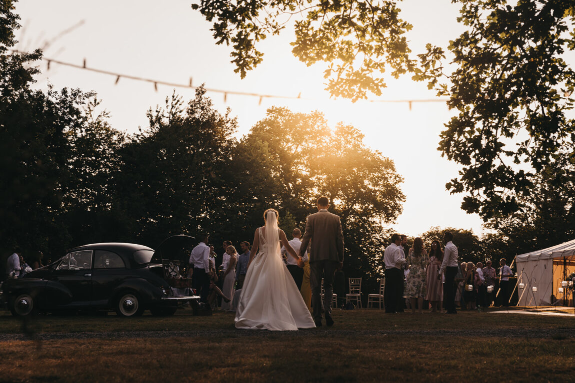 Nicola and Luke at sunset beside a vintage car at their Hoath House wedding, by Hoath House wedding photographer Matt Wing